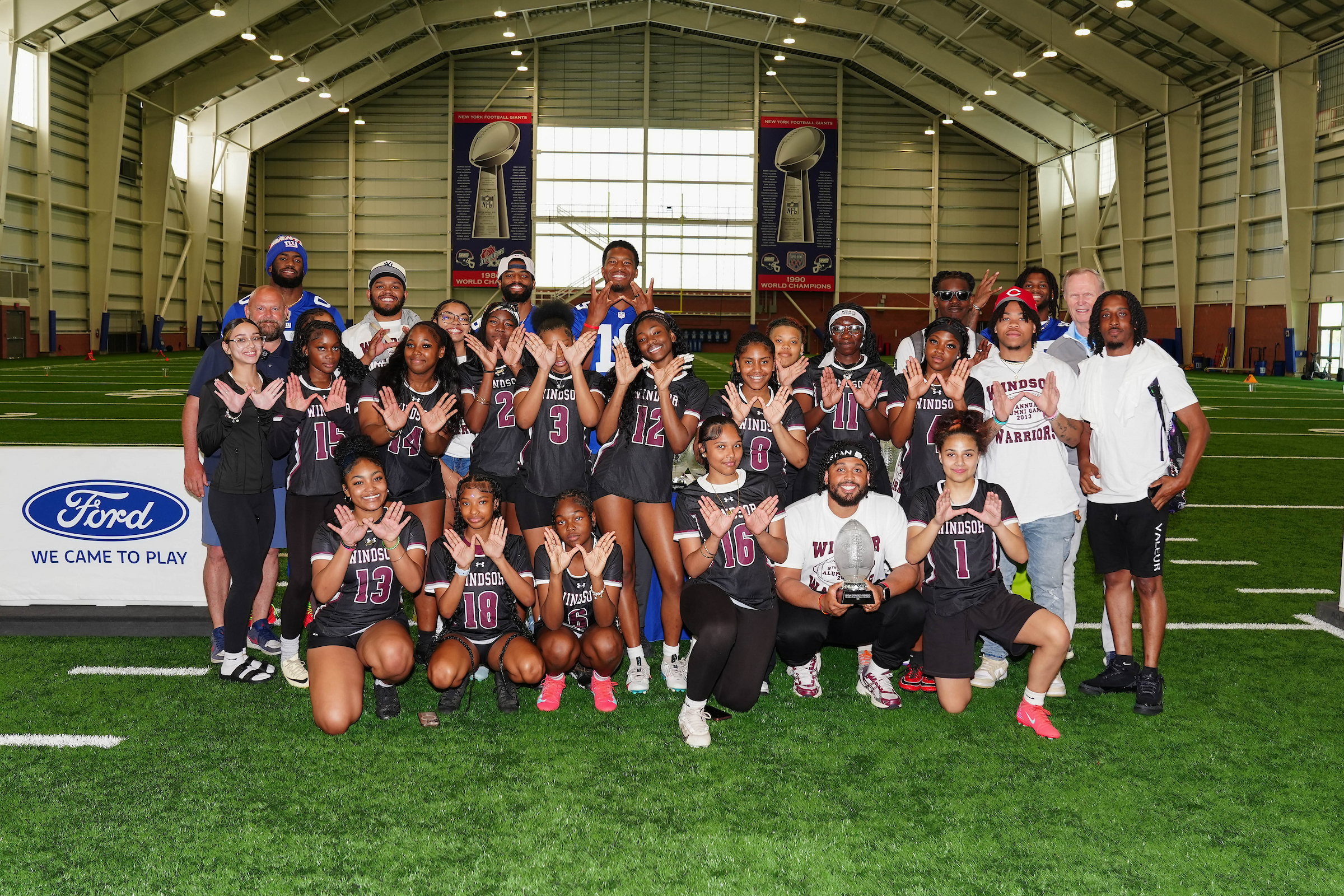 Windsor team celebration on football field with students and mentors